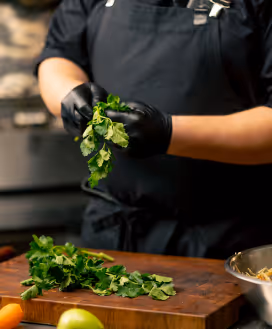 Chef prepping cilantro at restaurant
