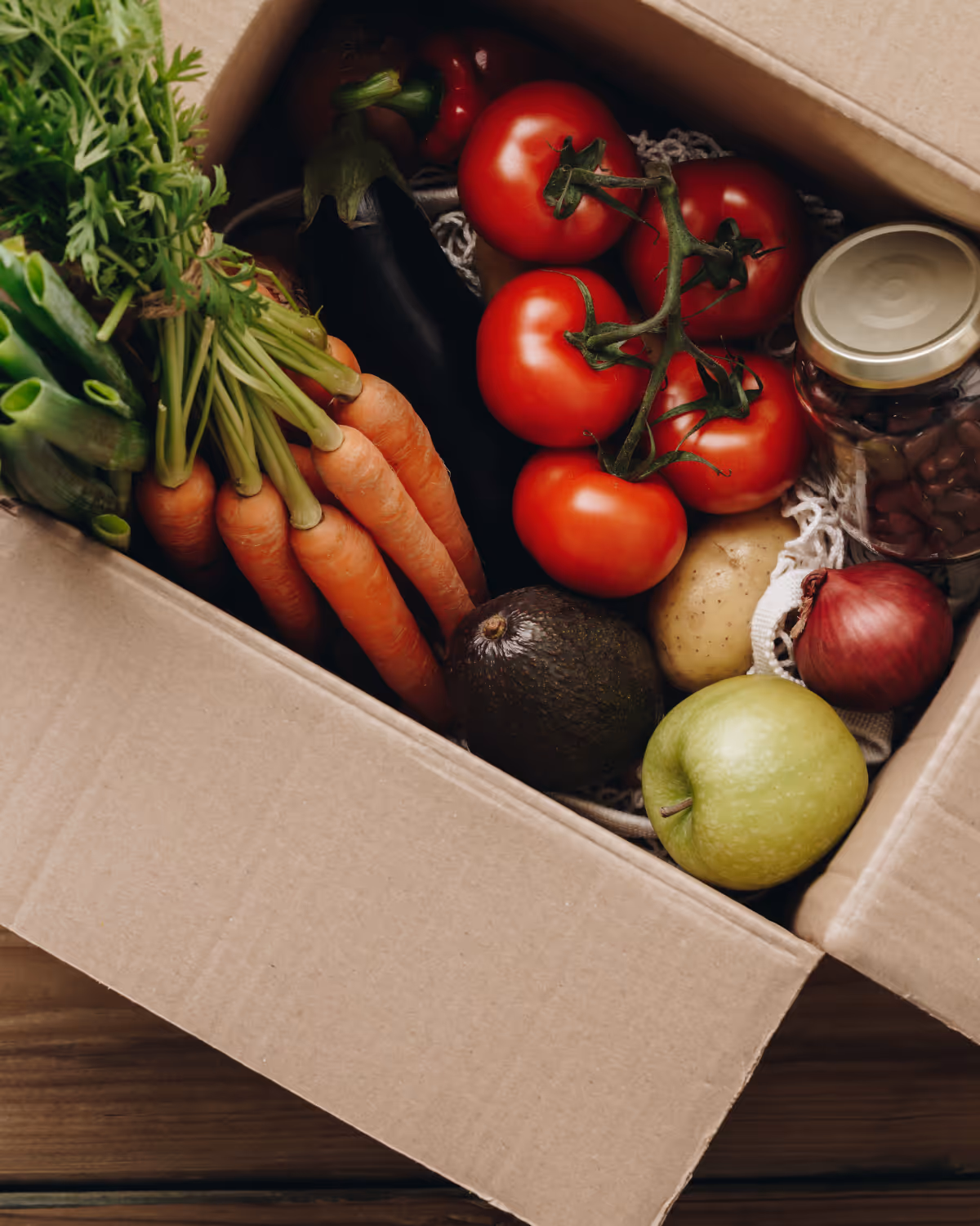 Food hub manager packing multi-vendor subscription boxes for delivery