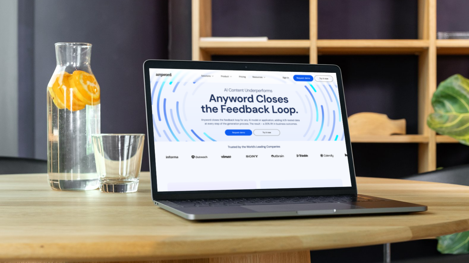 Laptop on a table showing Anyword's website screenshot