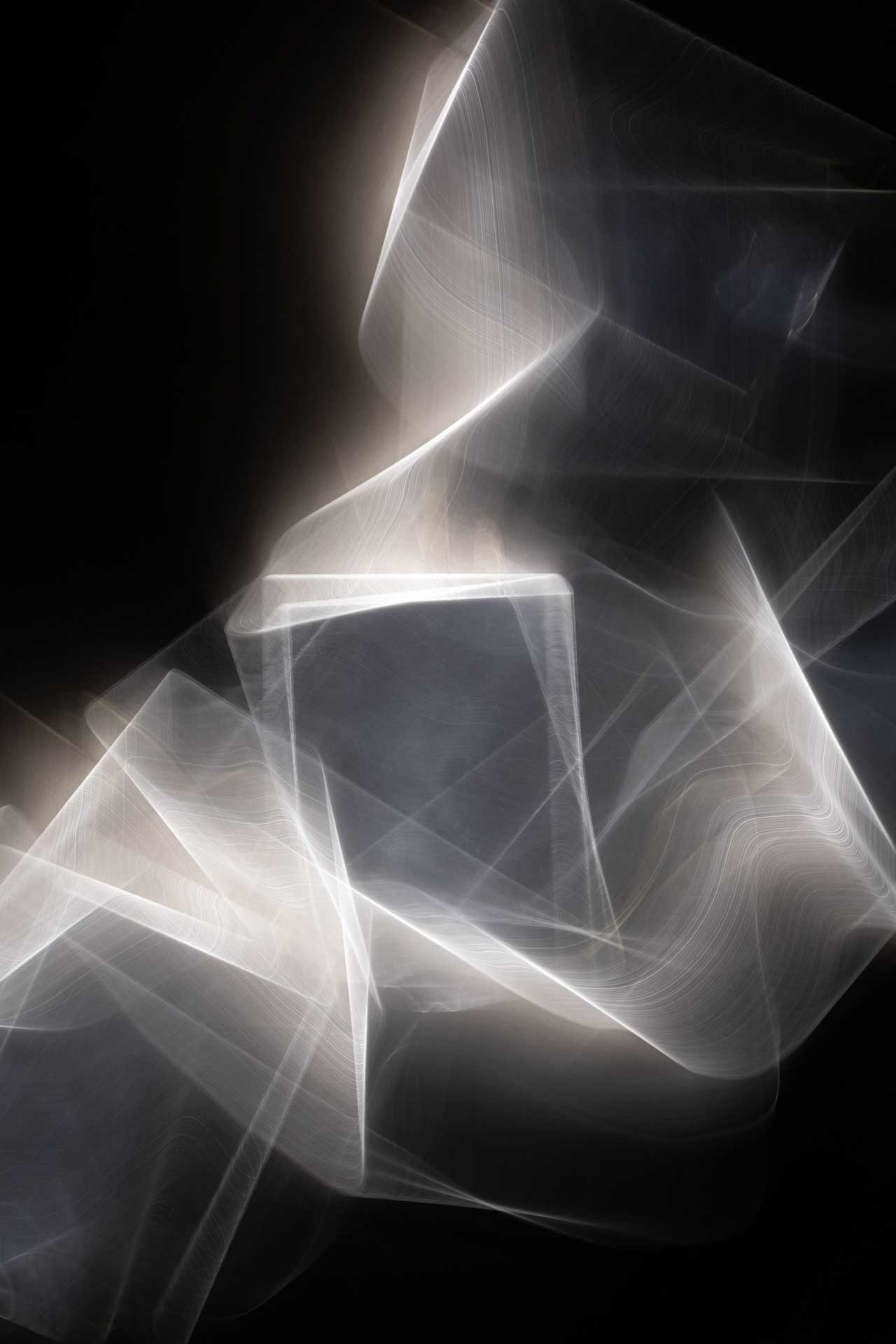 Abstract light painting with overlapping translucent white geometric shapes on a black background.