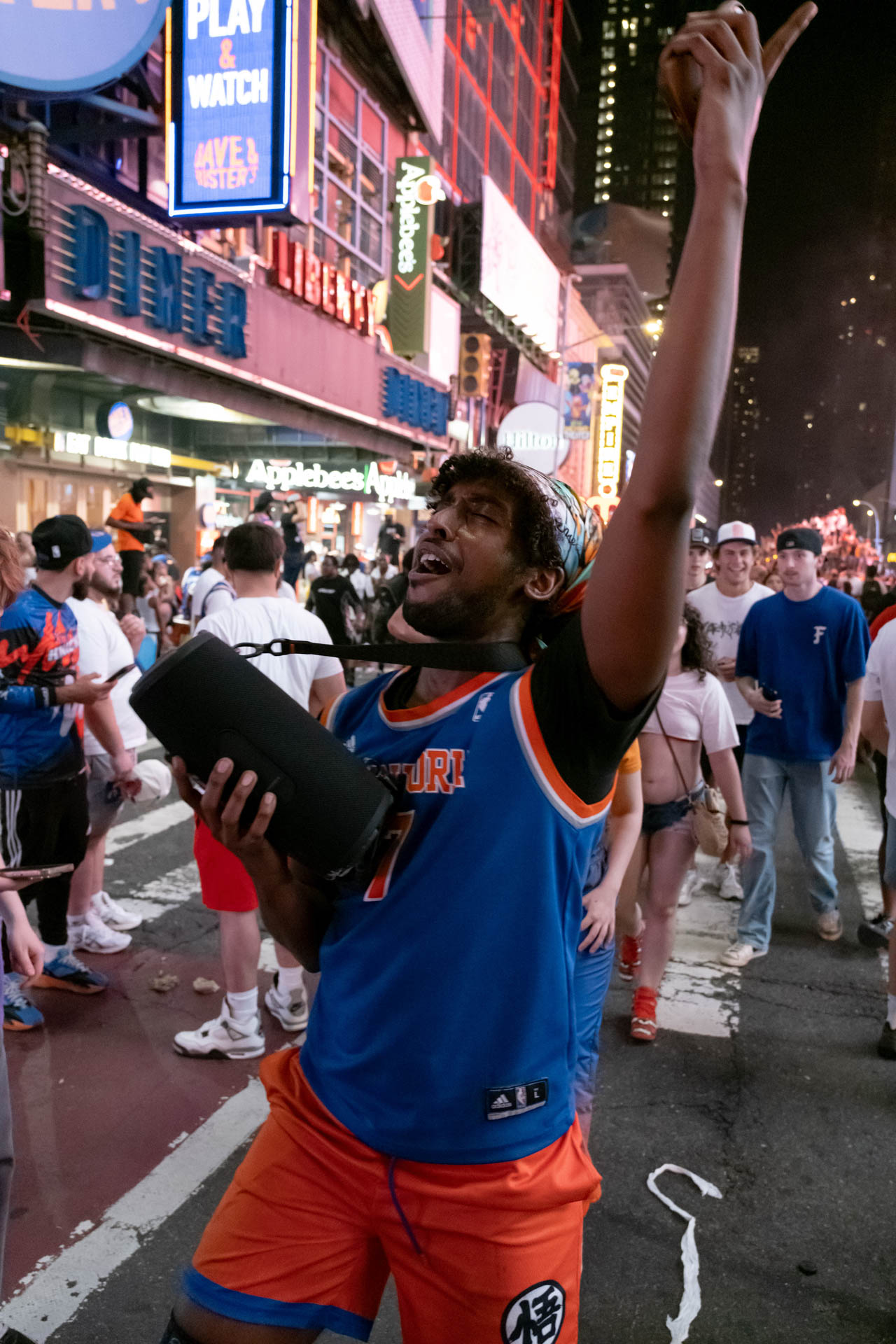 A man holding a speaker, raising his arm in celebration.