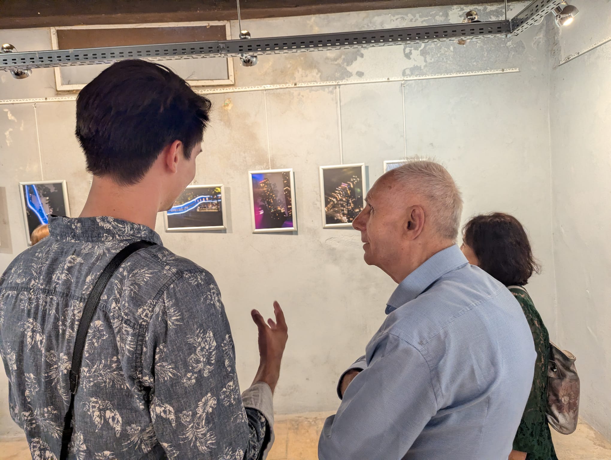 Two people conversing about a series of light-painting photographs.
