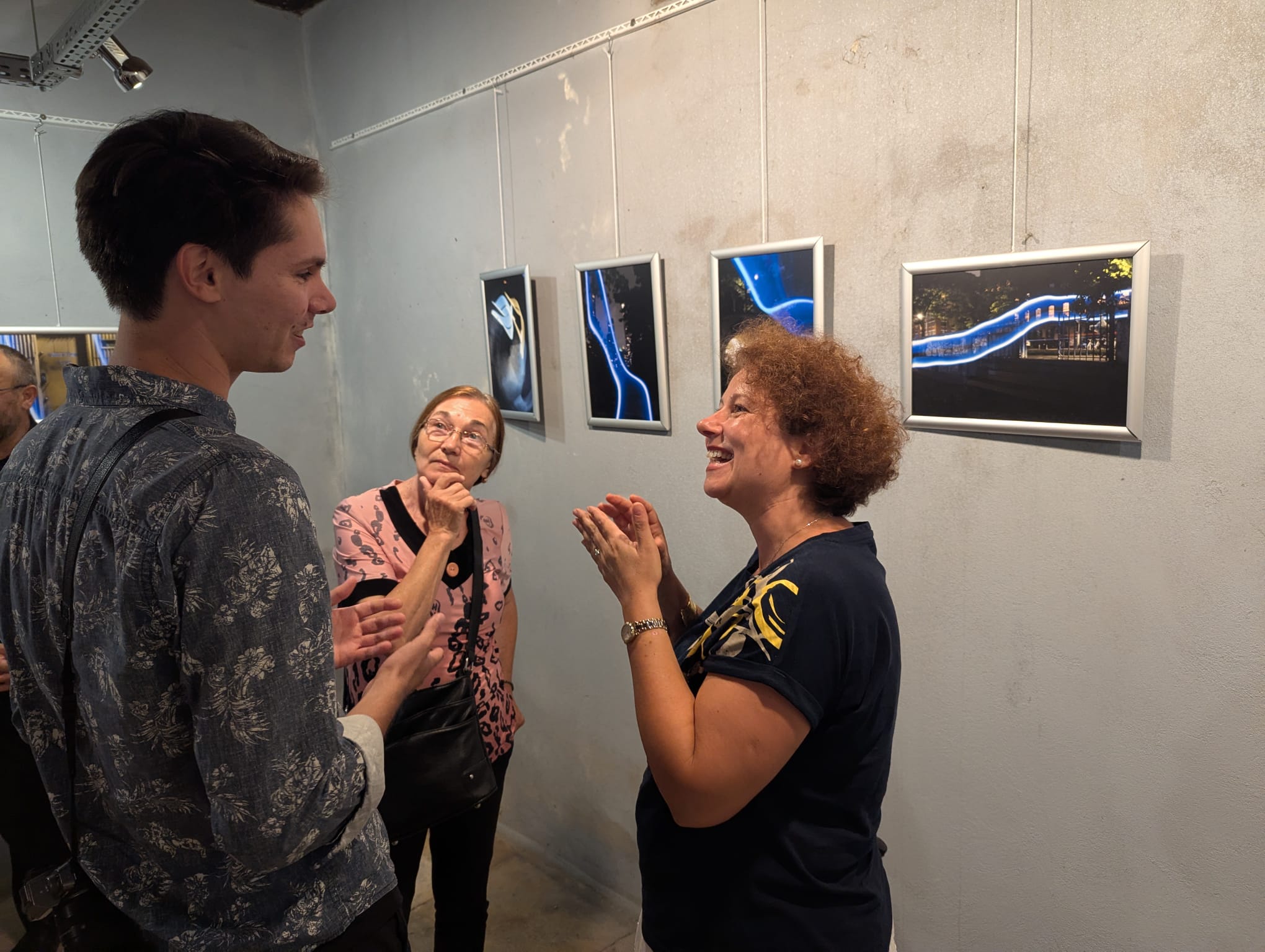 Three people conversing about a series of light-painting photographs.