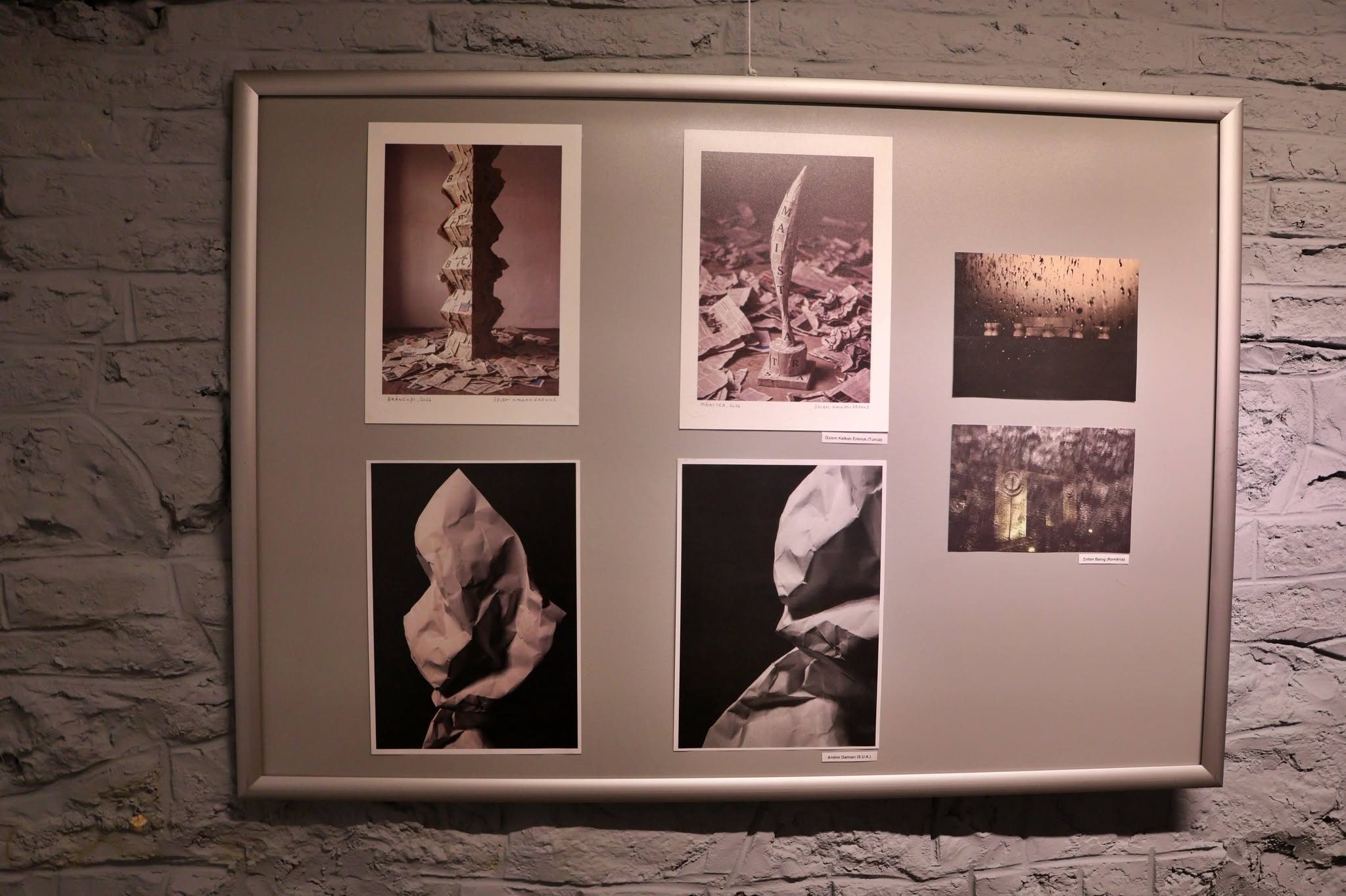 A collection of artworks on a poster board at a group mail art exhibition.