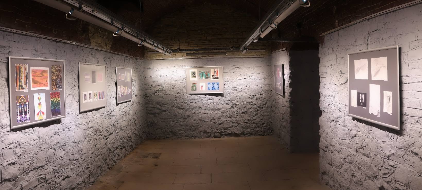 Artwork on walls in an exhibition space.