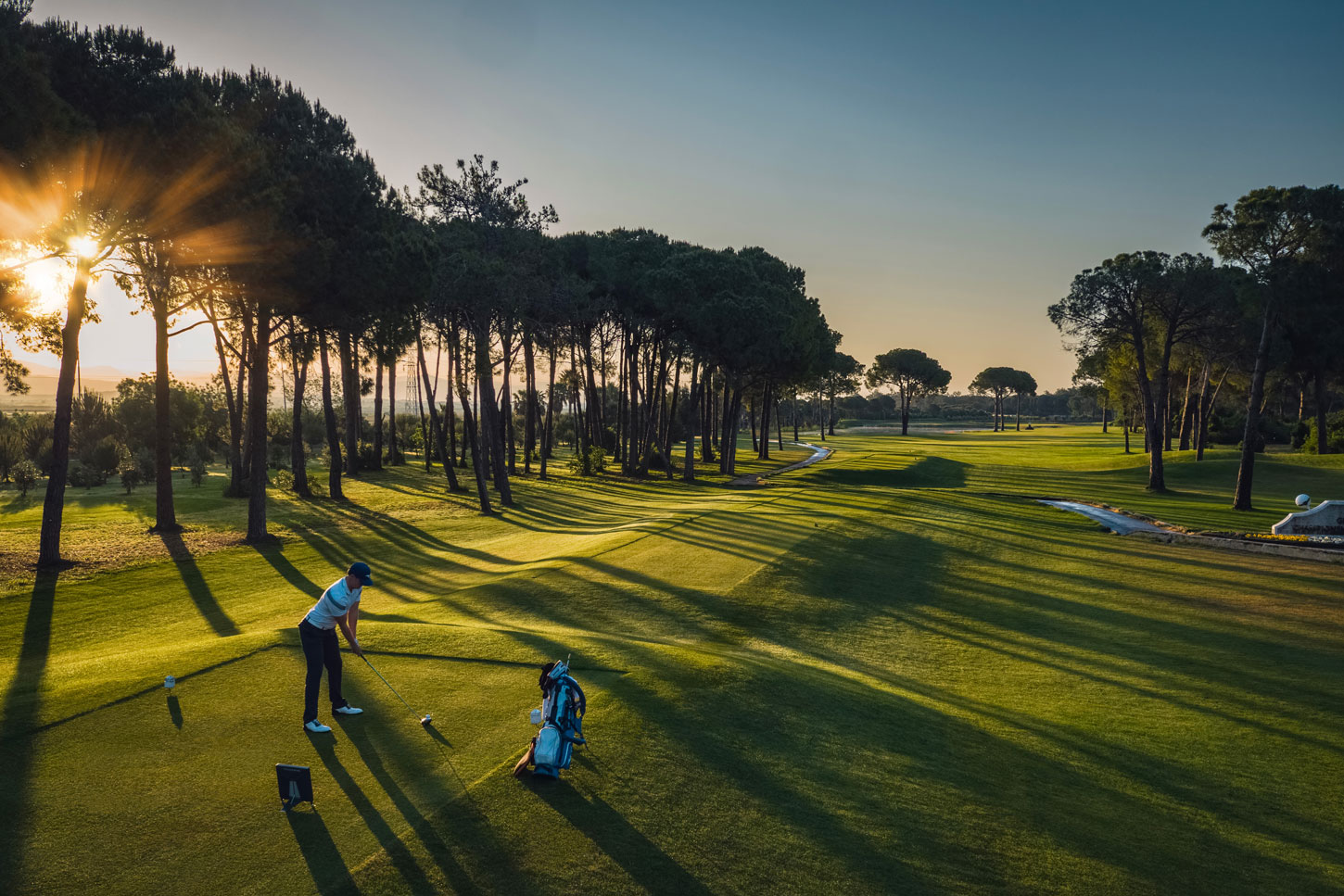 Player in the tee box and a sunset
