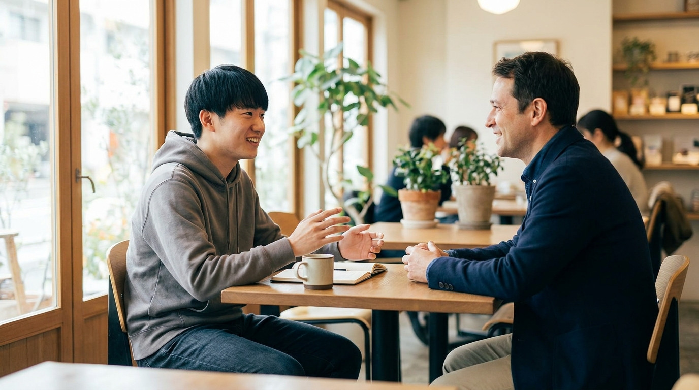 A college student having an informational interview with a professional at a cafe, both engaged in conversation over coffee