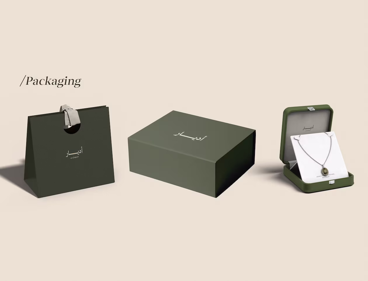 Dark green shopping bag, gift box, and jewelry box with necklace on beige background.