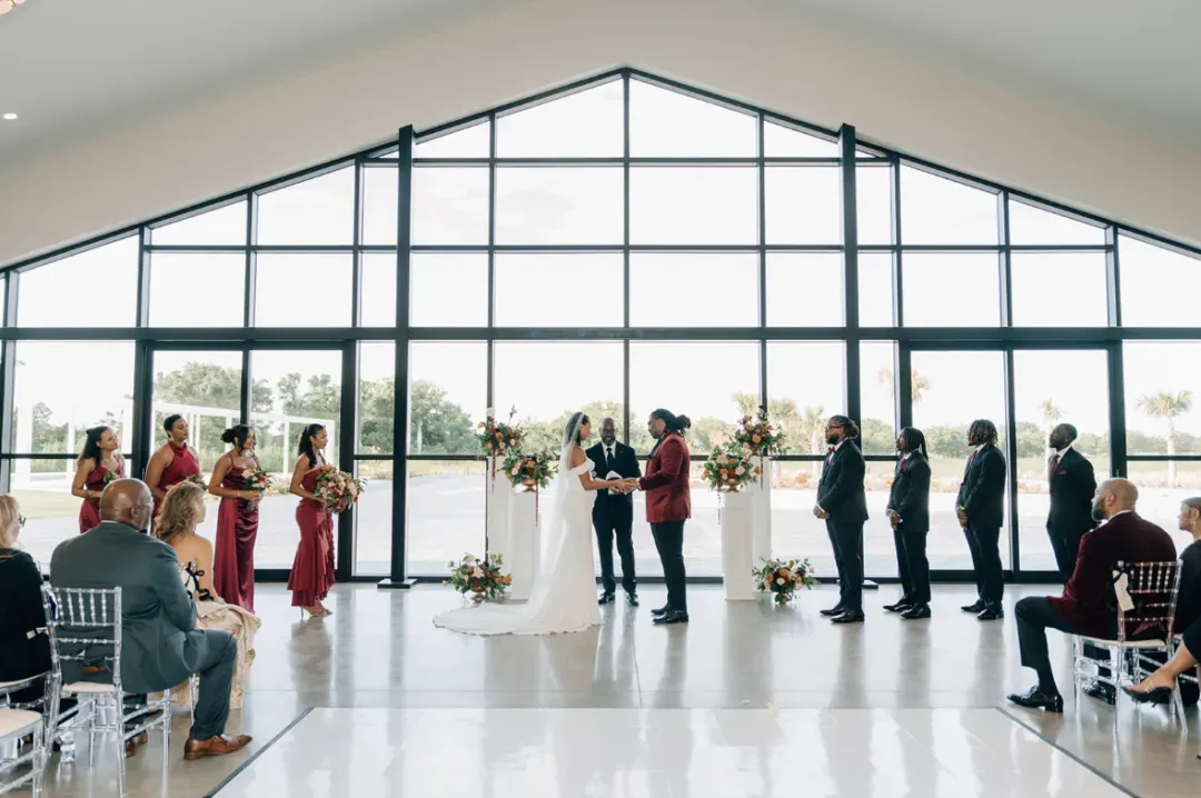 Indoor ceremony in front of the tall glass wall