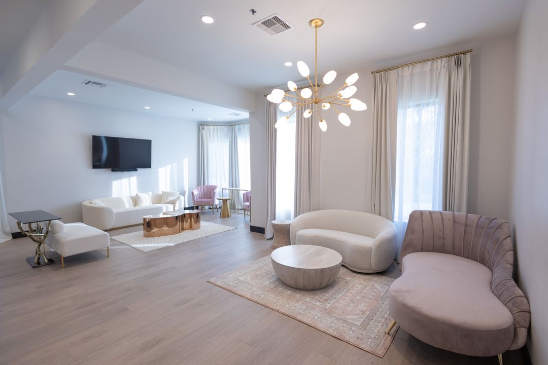 Bridal suite lounge with curved blush sofas and a starburst chandelier