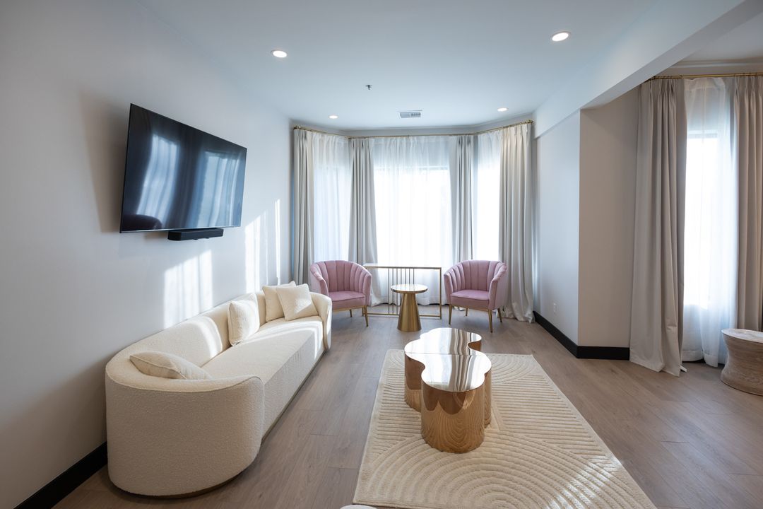 Bridal suite seating area with a cream curved sofa and gold coffee table