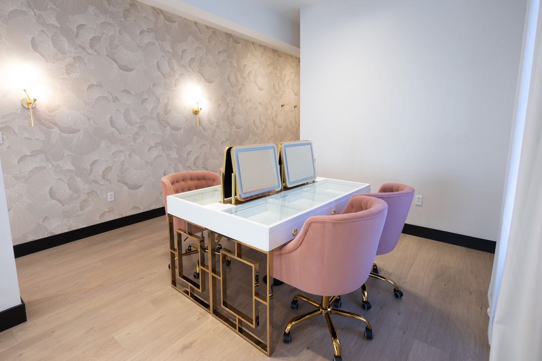 Bridal suite vanity with lighted mirrors and a white desk