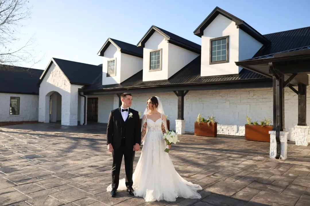 Bride and groom in front of the white venue building