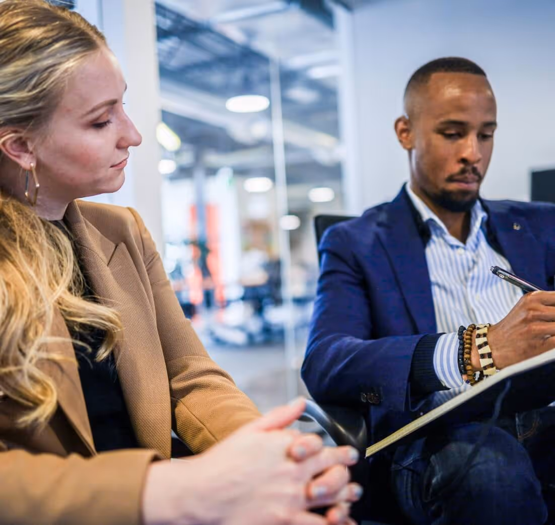 Business man and woman reviewing documents while sitting