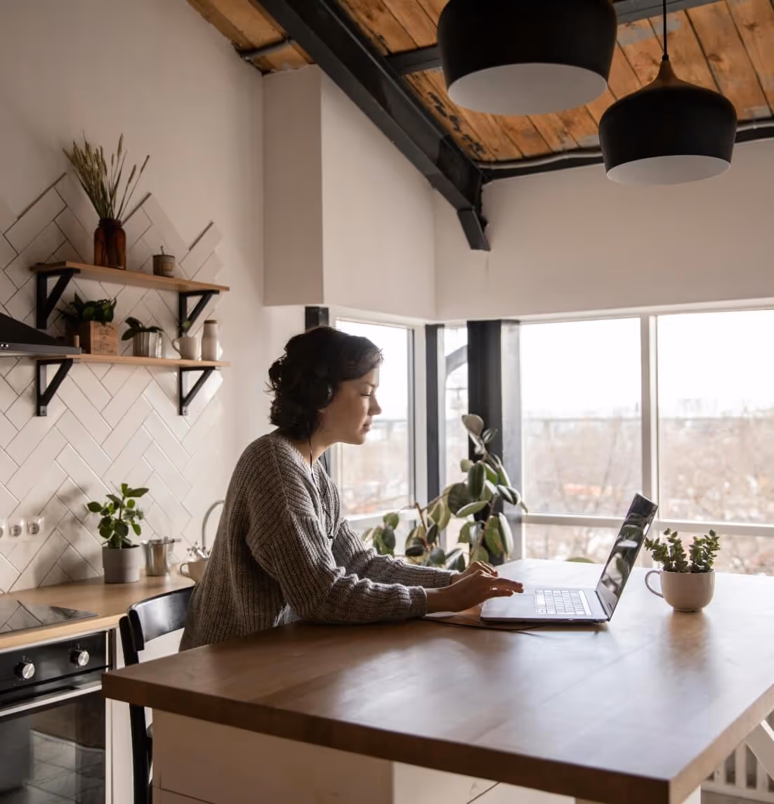 Image of a woman on her laptop at her kitchen table