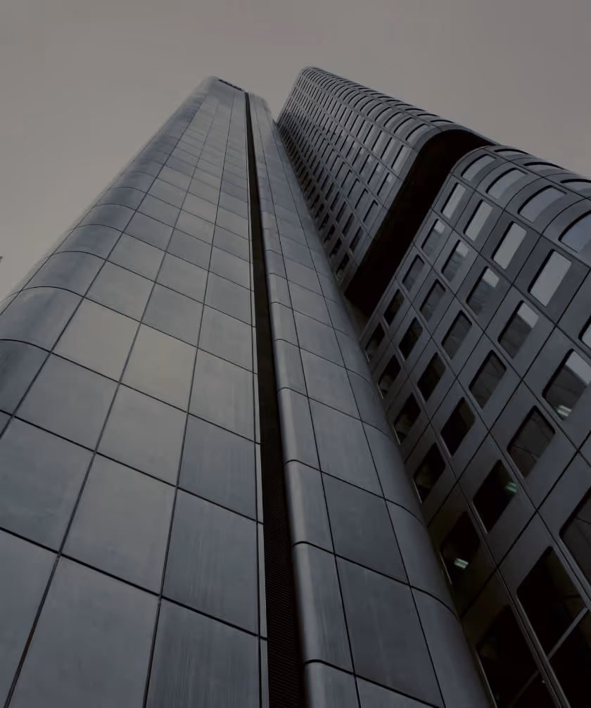 Image of a tall skyscraper from below with grey skies overhead