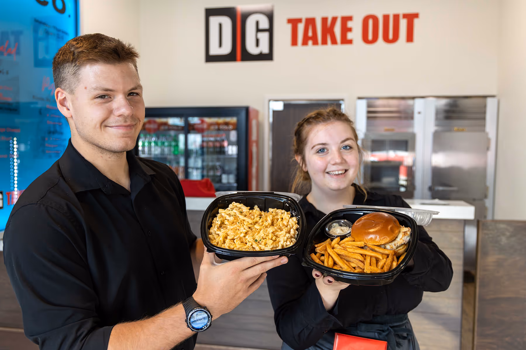 DG employees holding dishes prepared for takeout orders