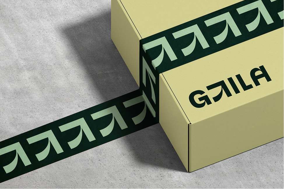 Pakke med grønn teip med GtilA symbol, på en gul eske med logo