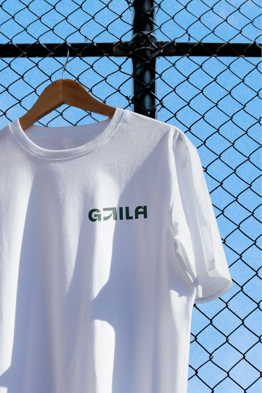 T-skjorte med GtilA logo, hengende på et gjerde