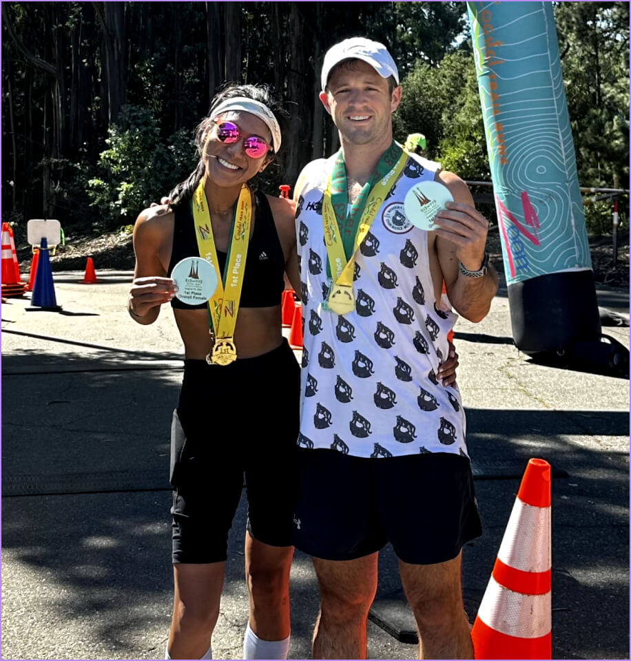 A man and woman are standing next to each other holding medals.
