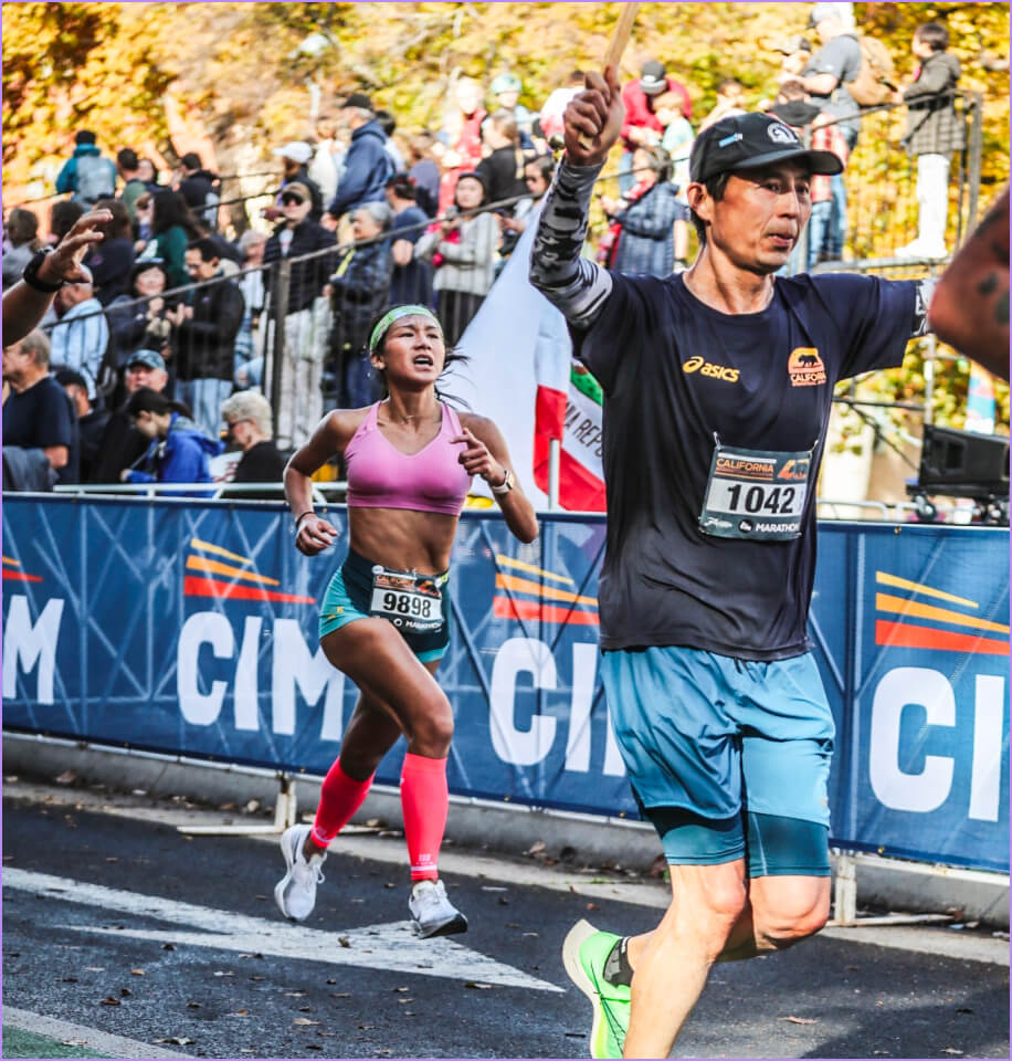 A man wearing a black hat and a blue shirt is running.