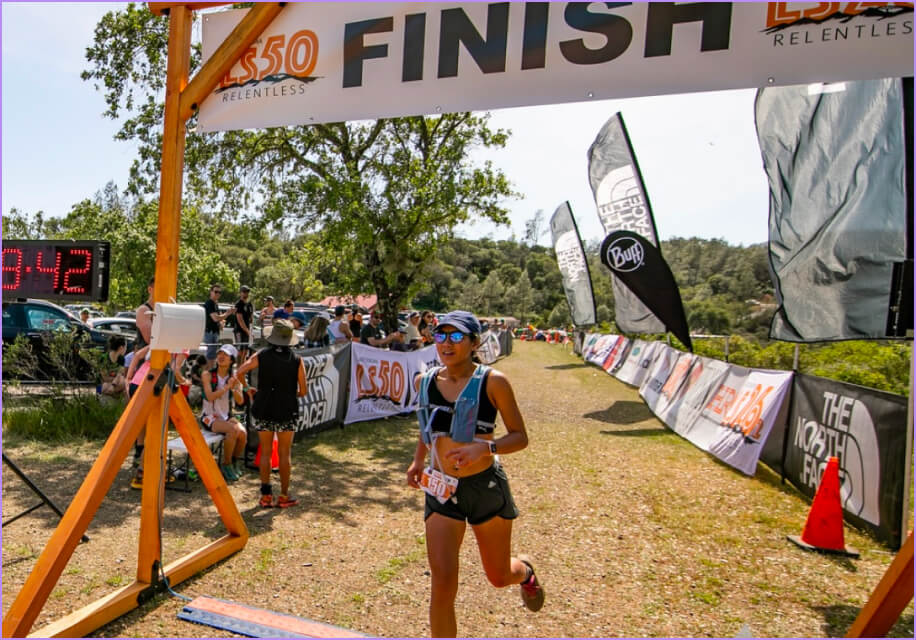 A woman running in a race with a sign that says 500 finish.