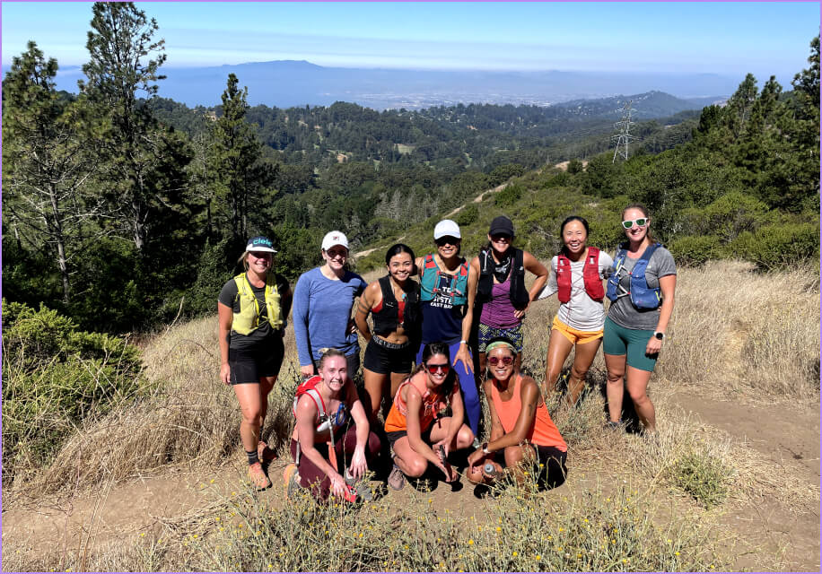 A group of women posing for a picture on a hillside.