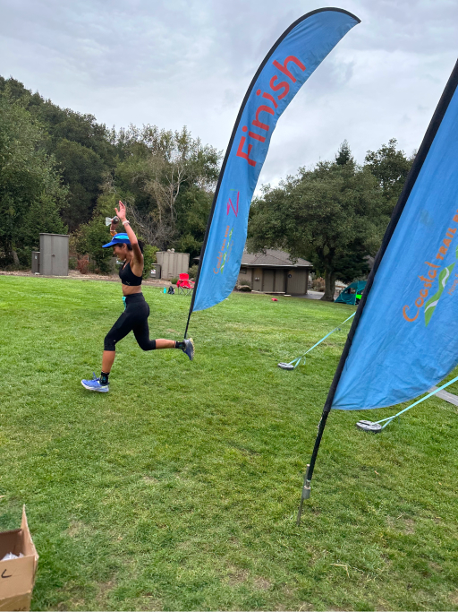 A woman running in front of two flags.