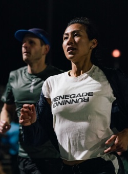 A woman wearing a white shirt with the word Renegade on it.