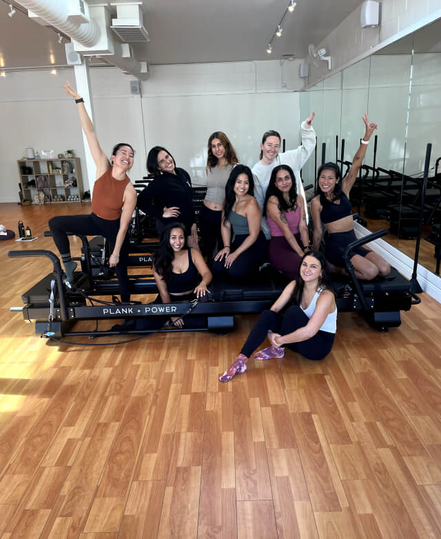 A group of women posing for a picture on a Plank Power machine.