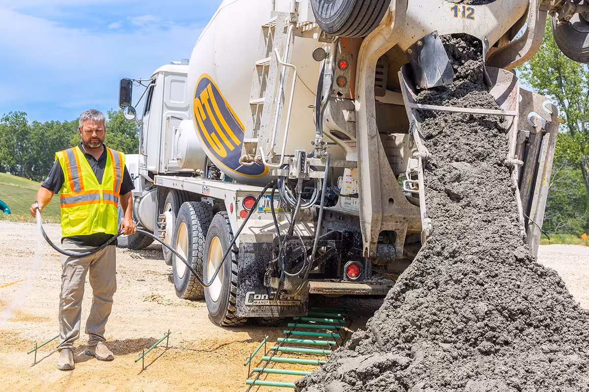 CTI Ready Mix Concrete services truck pour concrete in Elkhart, Iowa with CTI worker nearby