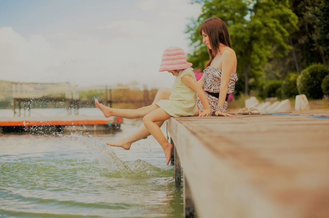 Woman and daughter sitting on a dock