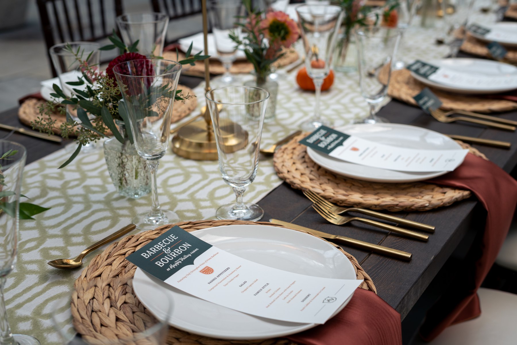 Floral arrangements, glassware and place settings prepared for the farm dinner