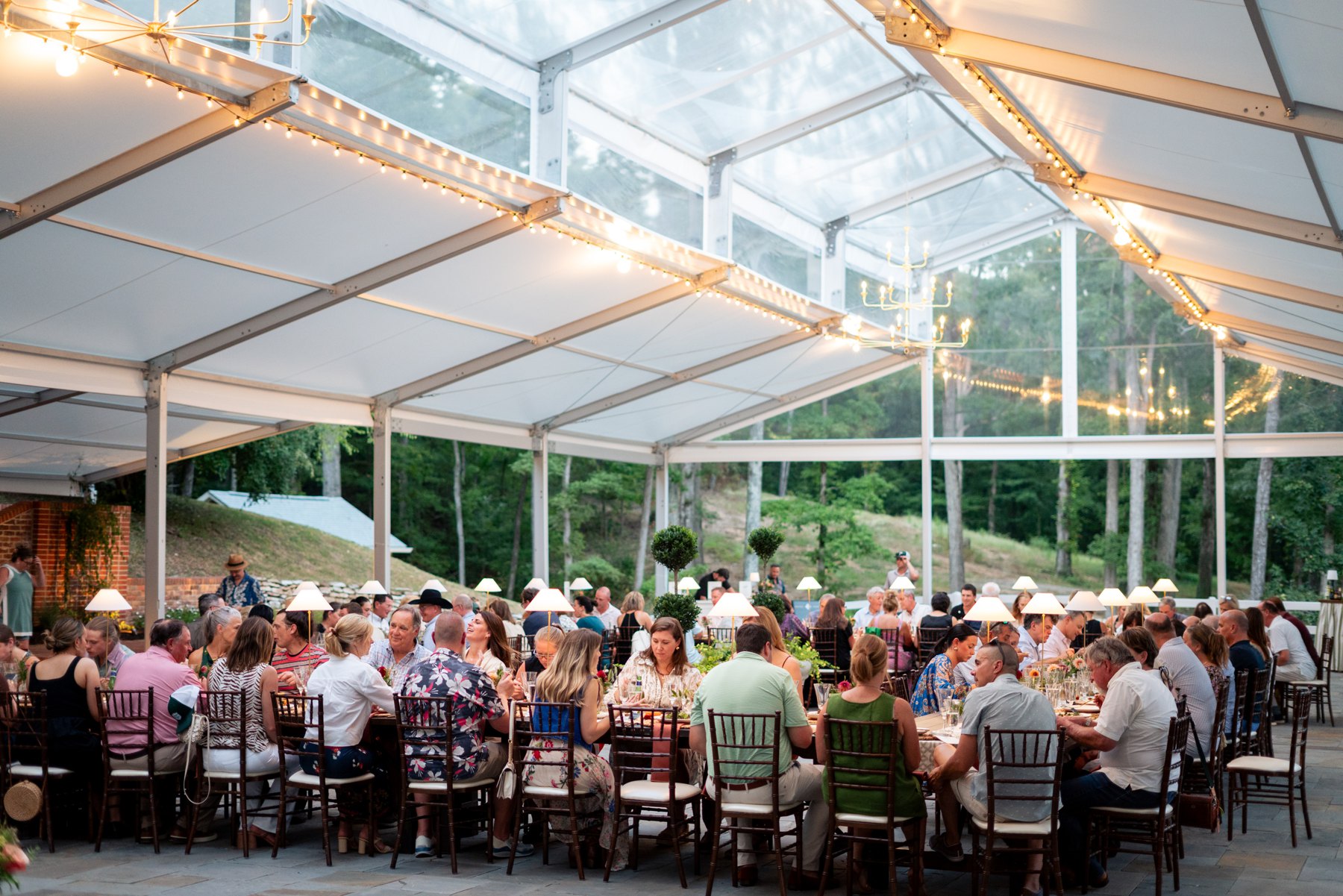 Guests gathered beneath the clear tent for Barbecue & Bourbon at Happy Valley Farms