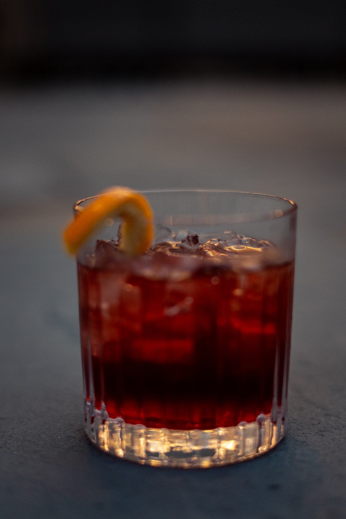 A bourbon cocktail with an orange garnish