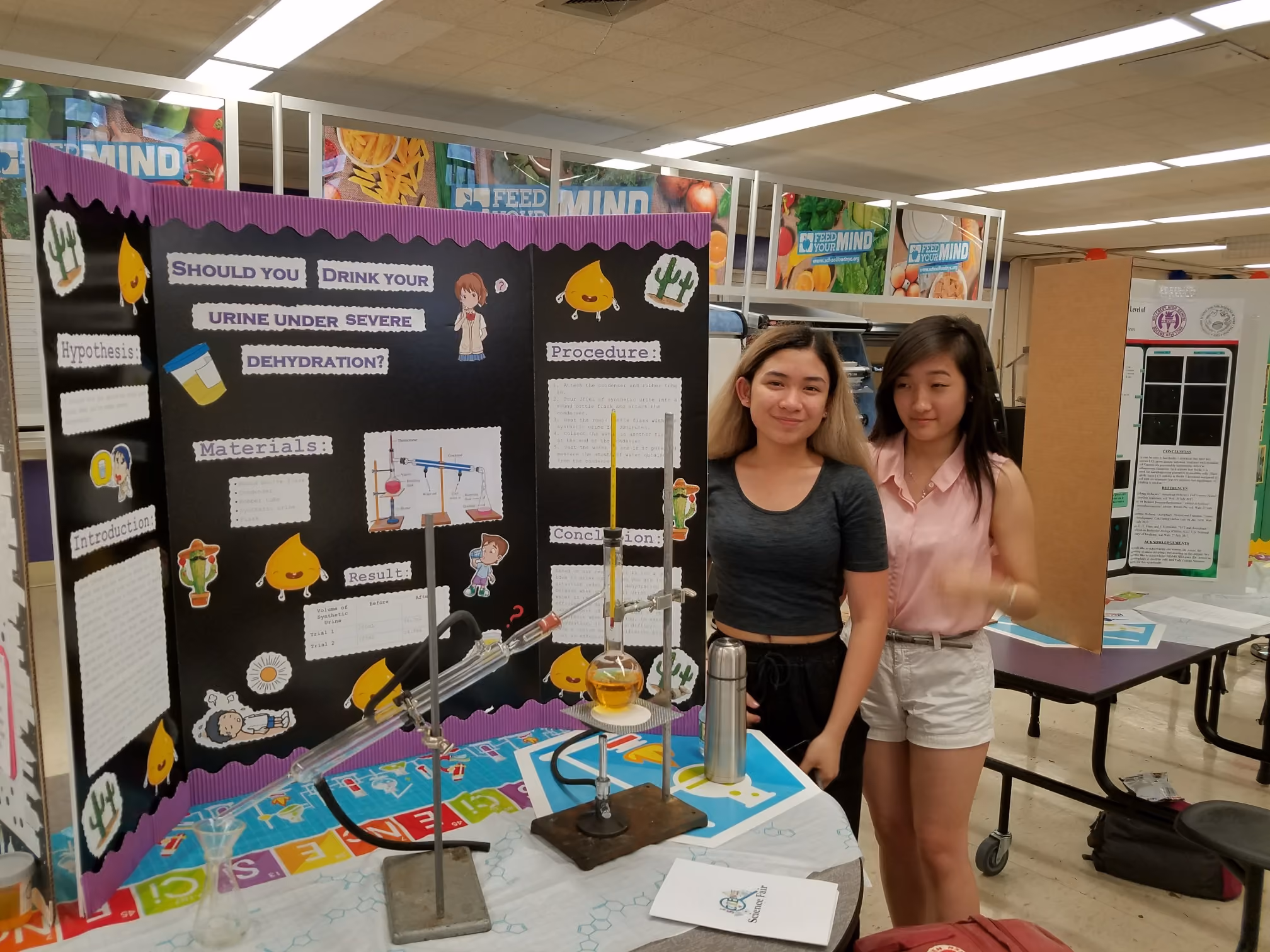 Two students presenting science fair project on drinking urine during dehydration