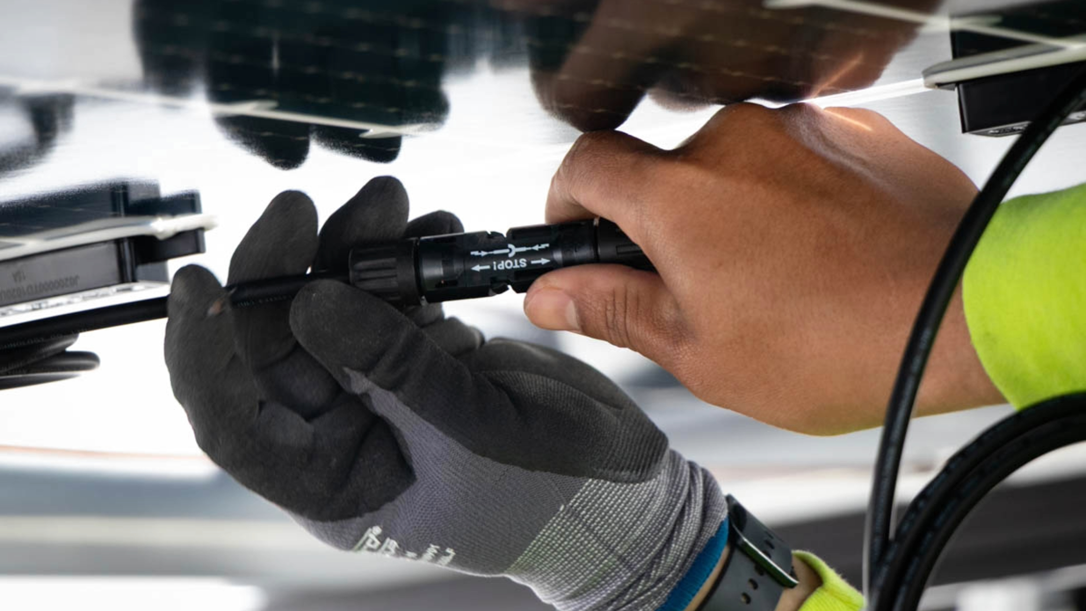 A technician connects wiring for a solar array.