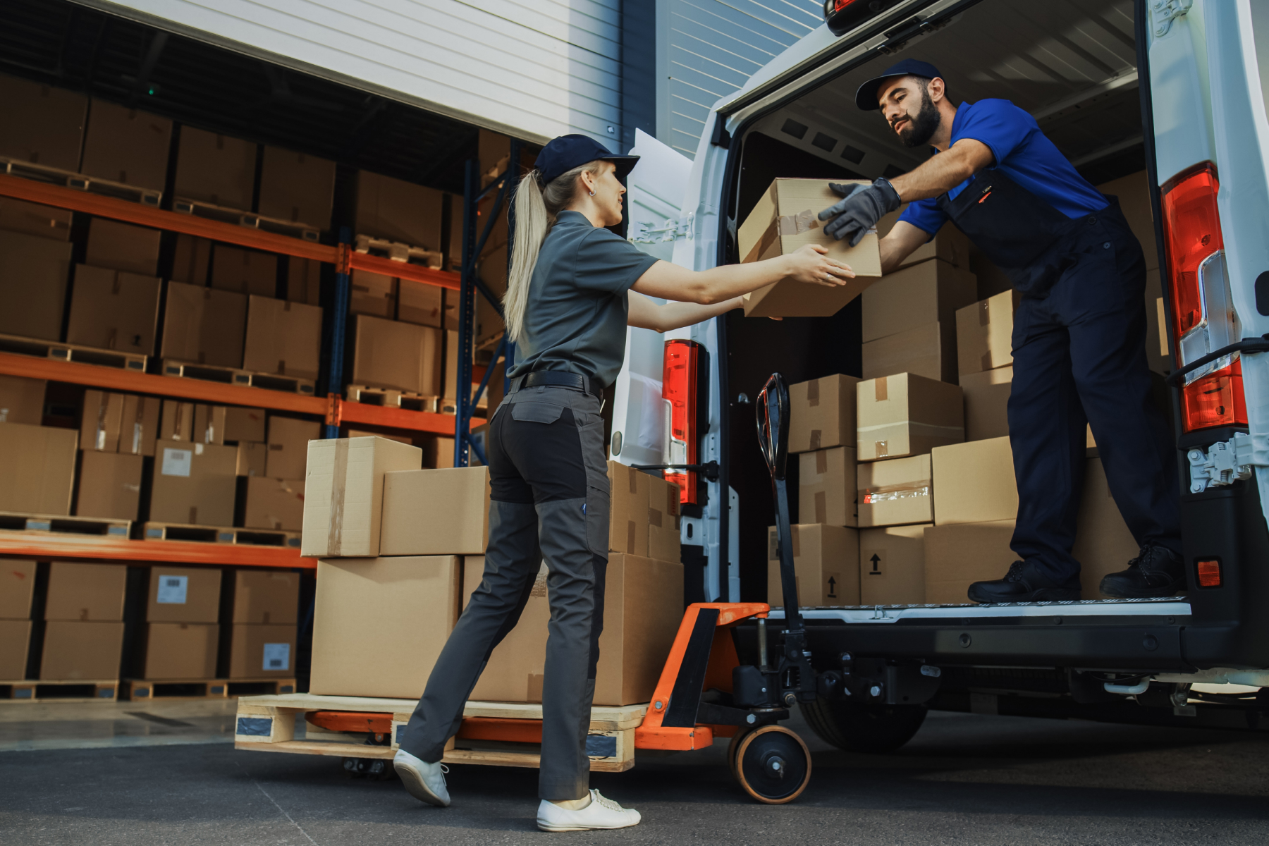 Two men loading boxes onto a moving truck.