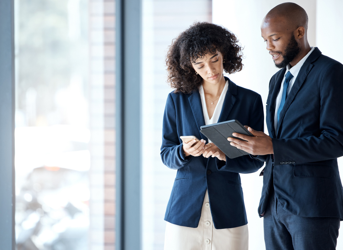 Businessman and business woman talking with each other and holding tablets.