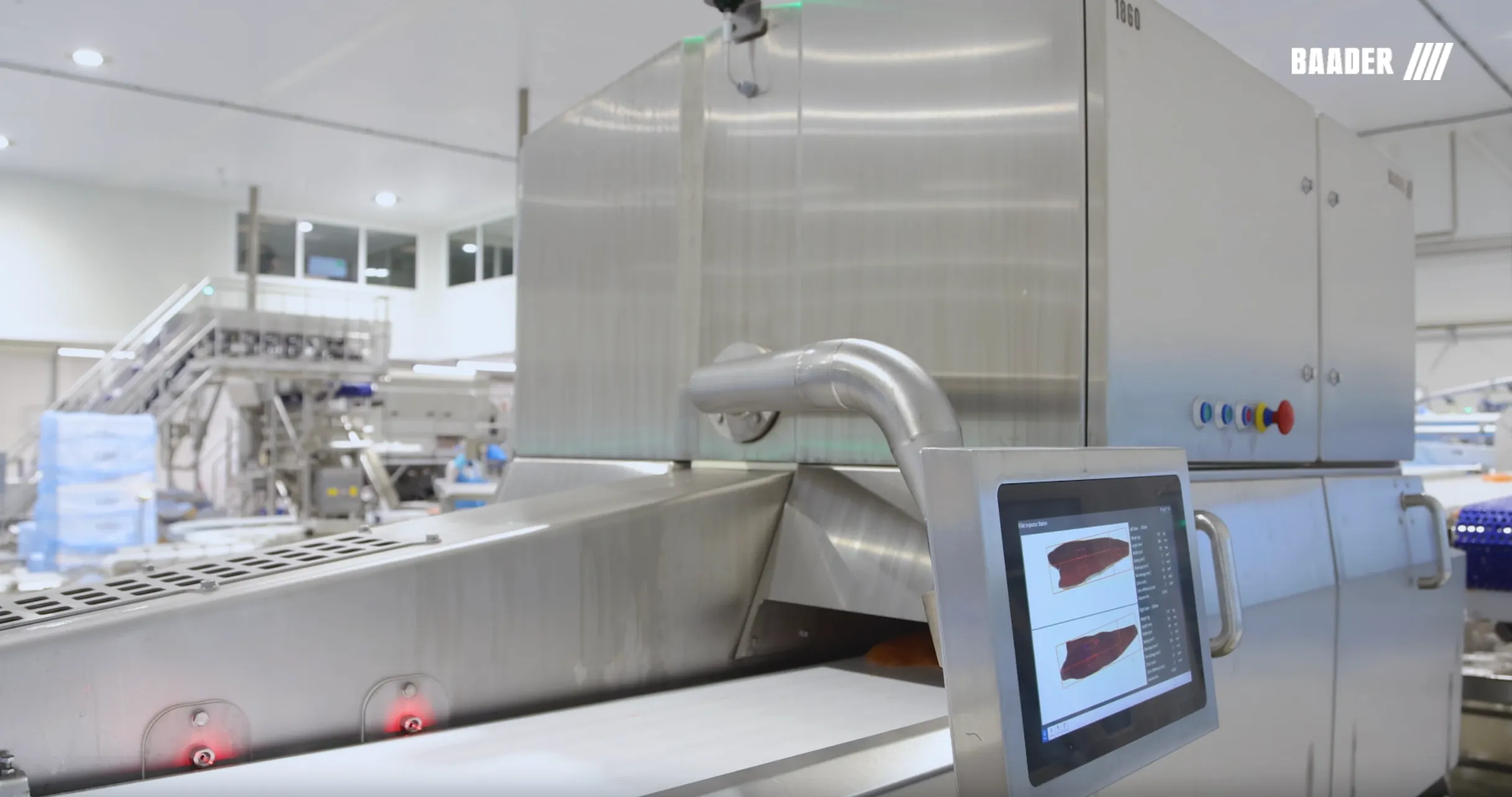 Industrial food processing machine with a conveyor belt and touchscreen displaying meat images in a factory setting.