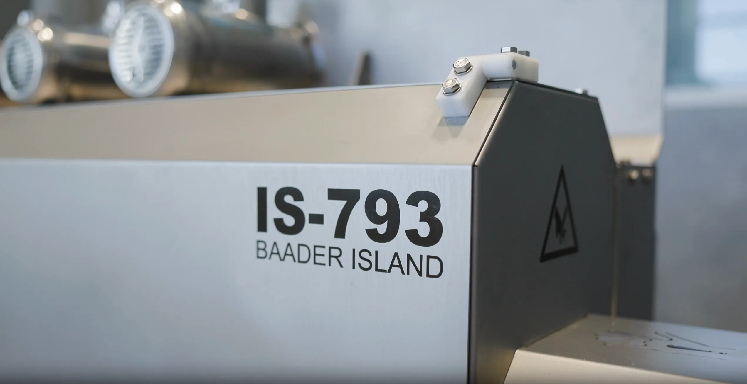 Close-up of industrial equipment labeled IS-793 Baader Island with a high voltage warning symbol.