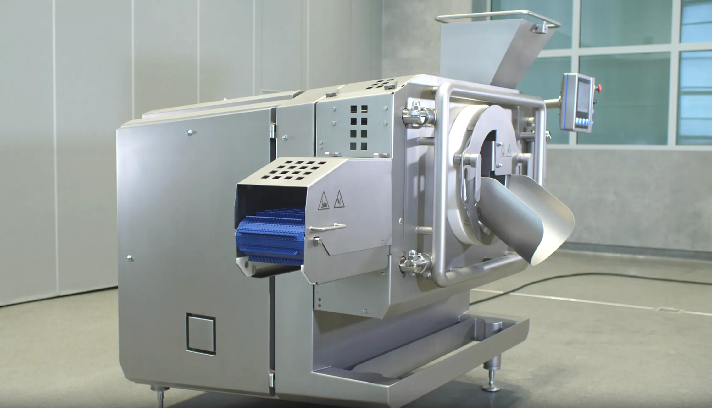 Industrial Baader 608 machine with stainless steel body and blue conveyor belt in a clean room.