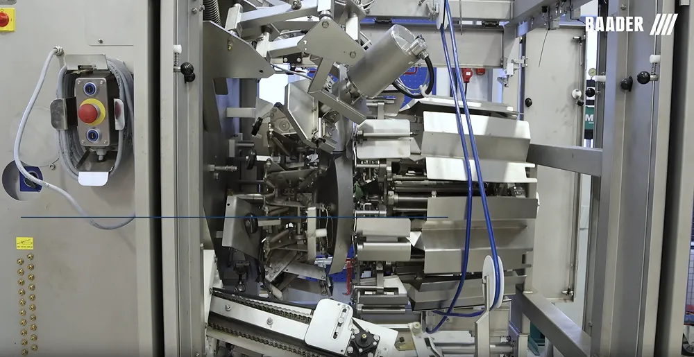 Close-up of stainless steel Baader industrial processing machine with mechanical parts and cables.