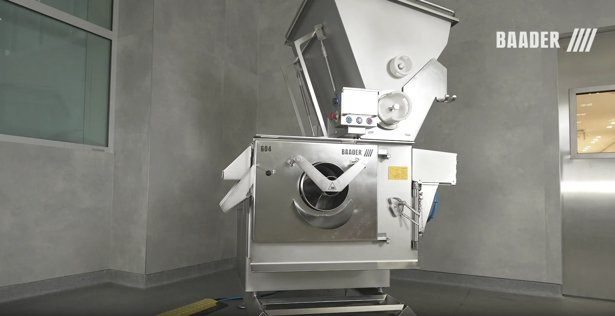 Stainless steel industrial machine with BAADER branding in a clean room.