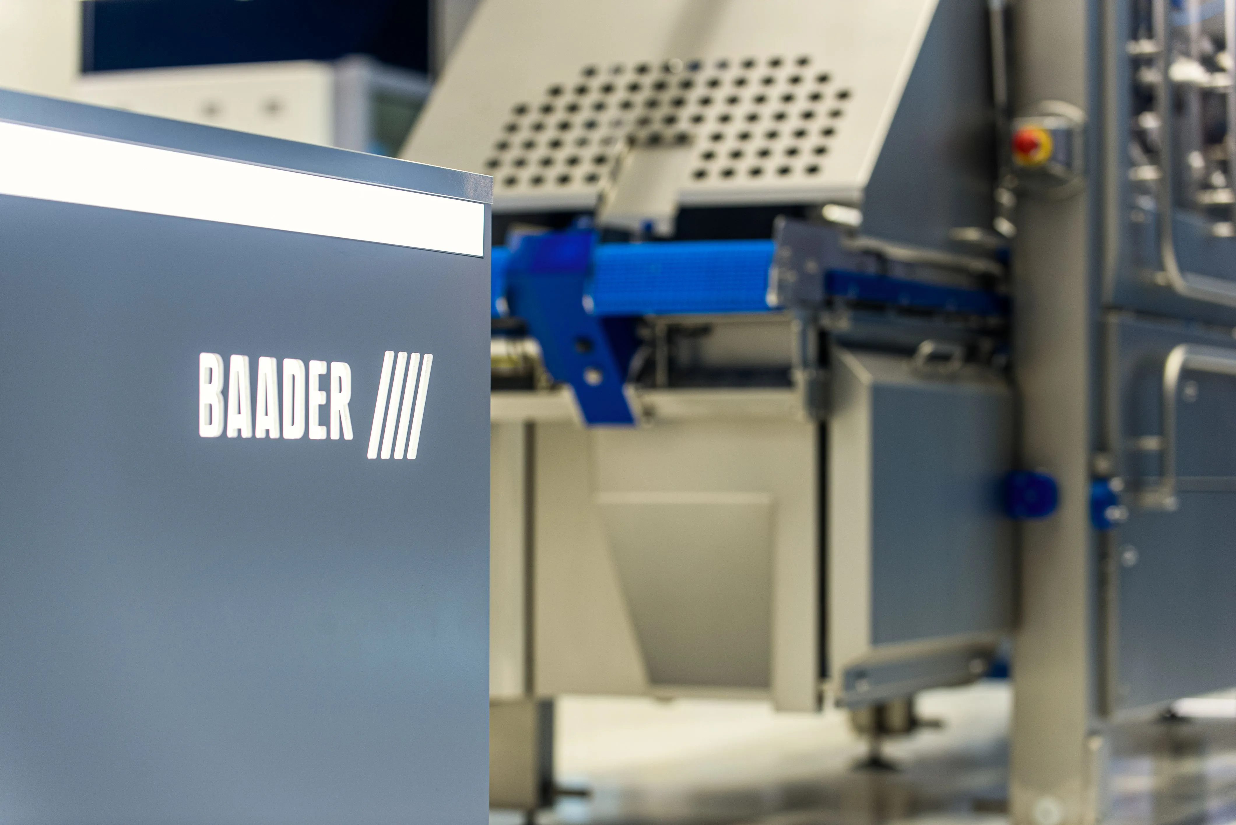 Close-up view of a BAADER industrial machine with blue and gray components in a processing facility.
