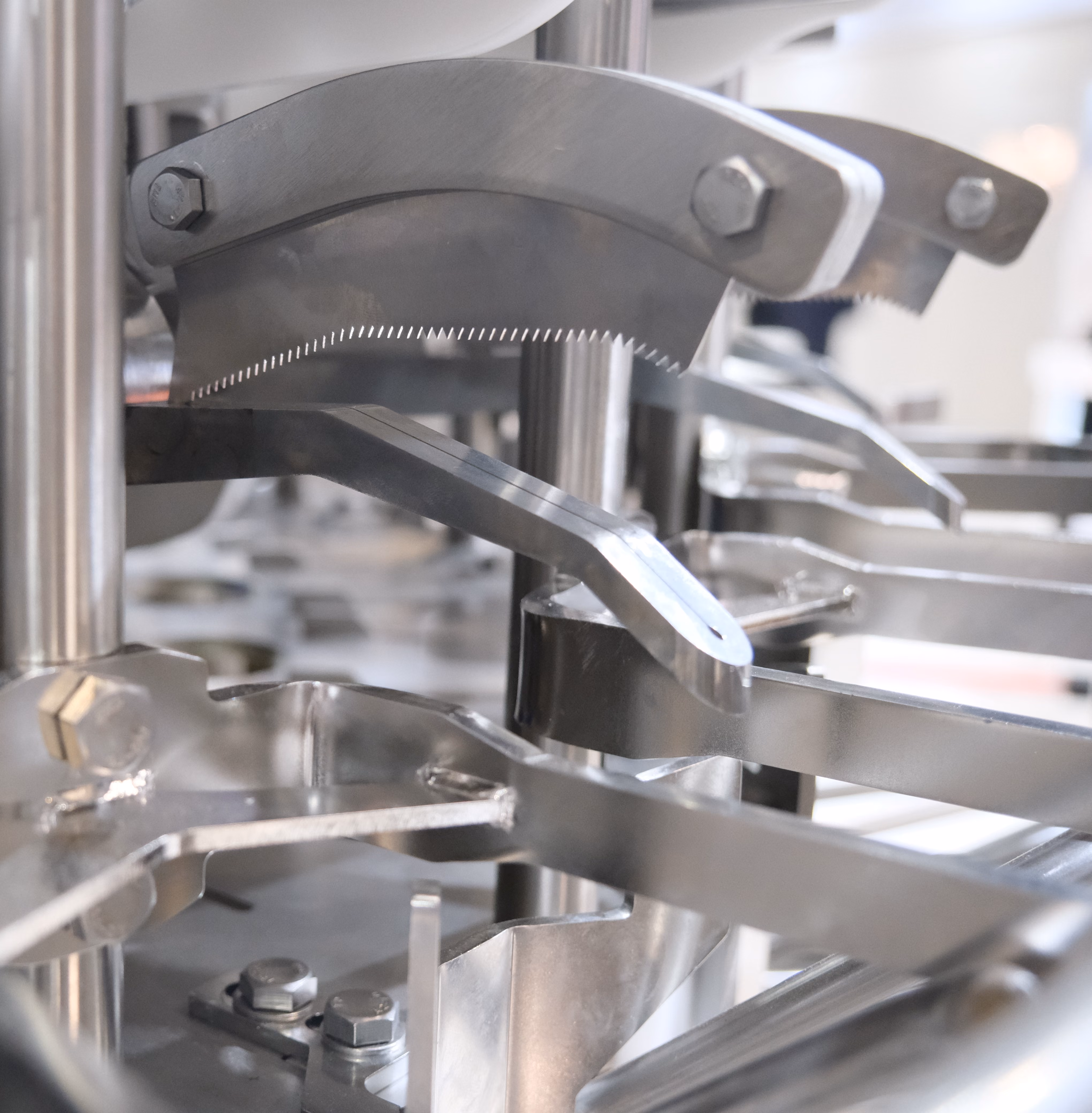 Close-up of industrial metal machine parts and fasteners with curved serrated components.