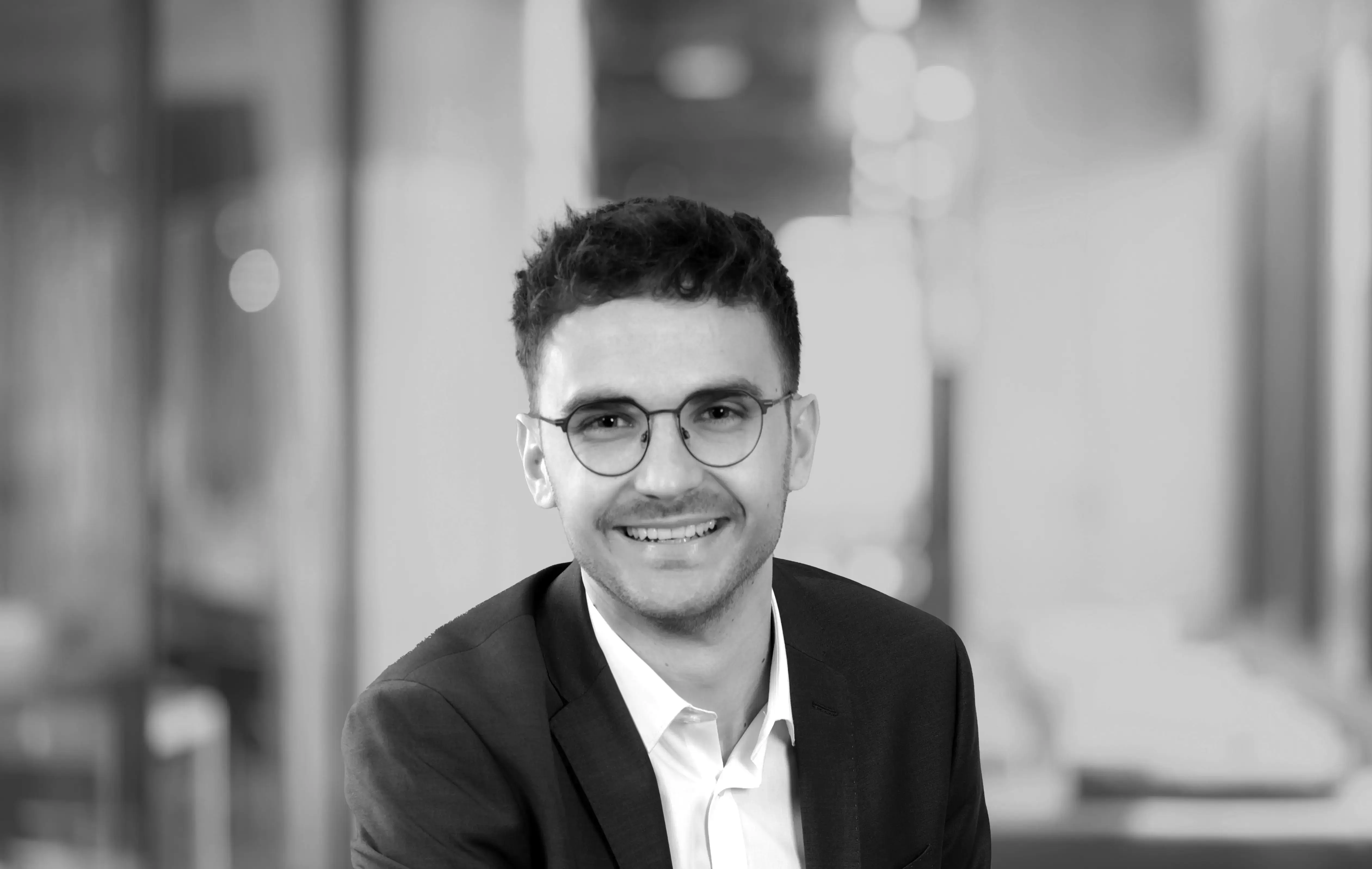 Portrait von einem Mann mit Brille in schwarz weiß. David Skowasch, verantwortlich für den strategischen Einkauf und Projektmanagement bei ims