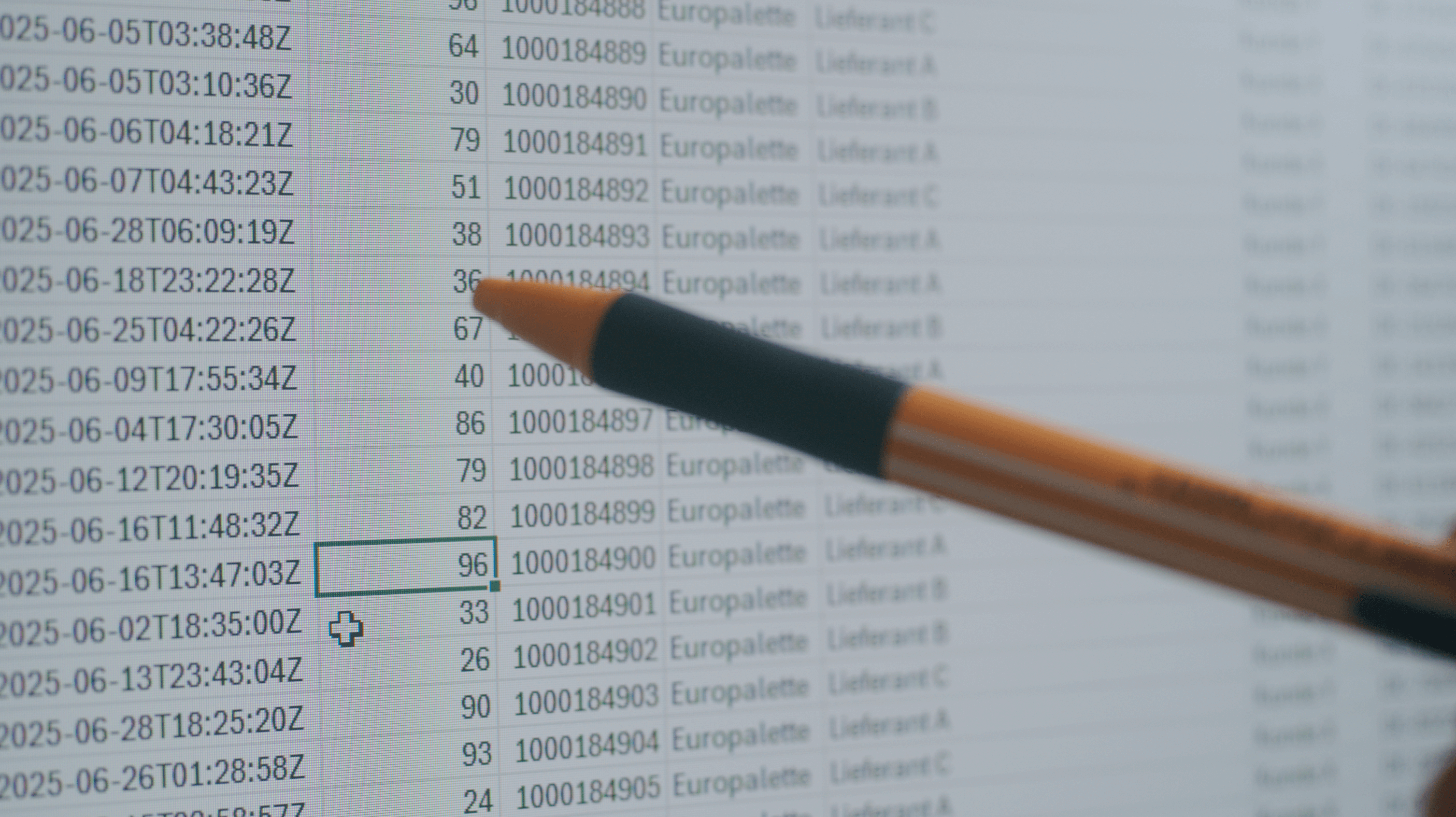 Nahaufnahme eines Computerbildschirms mit einer Excel-Tabelle voller Zeitstempel und Paletten-Daten. Ein Kugelschreiber zeigt auf eine markierte Zelle in der Tabelle.