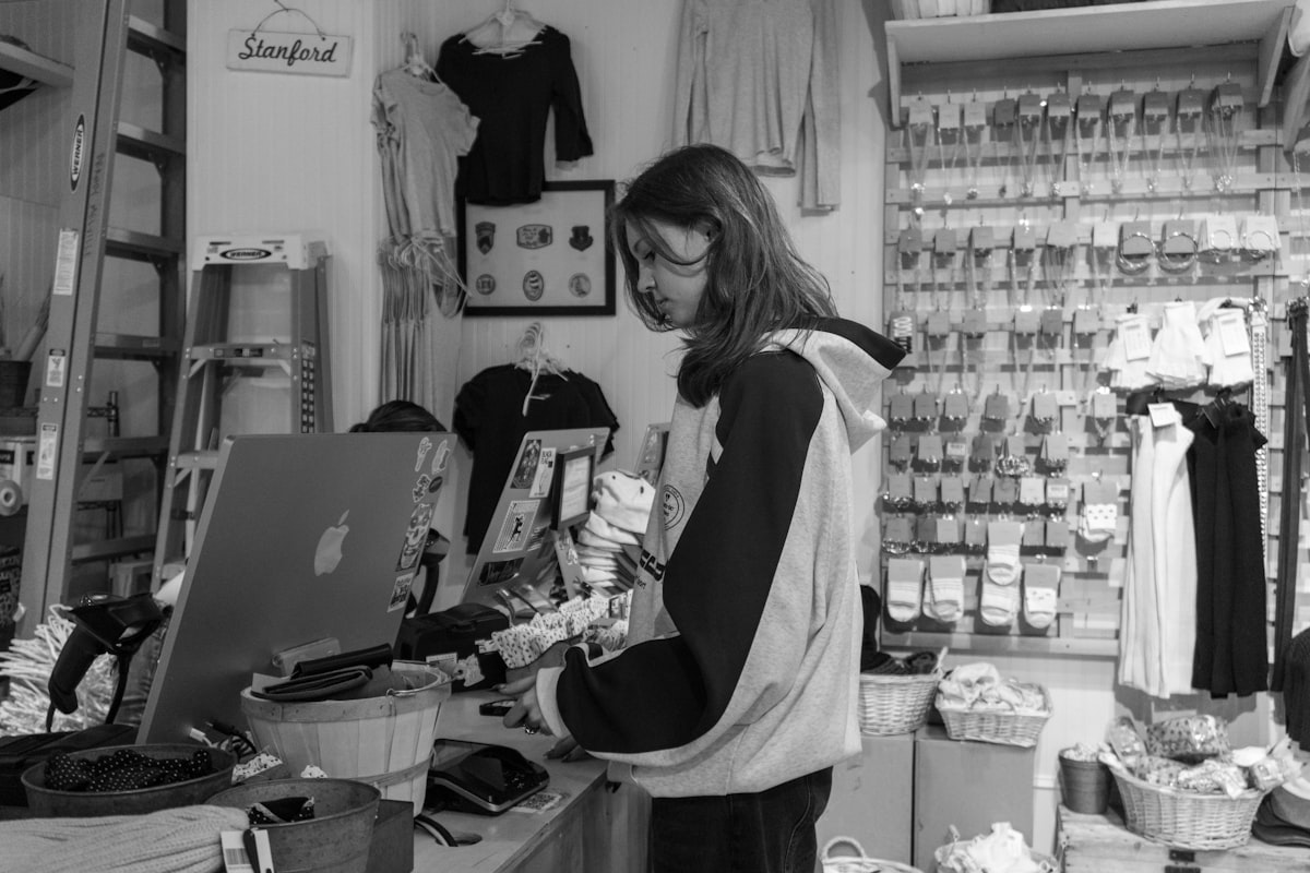 Independent retail shop owner using a card machine at the counter
