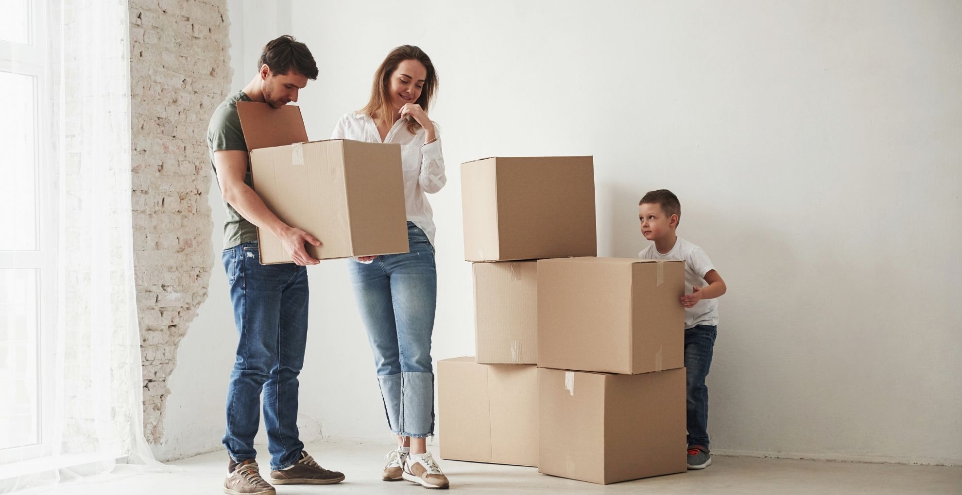 koppel met kind aan het verhuizen met dozen
